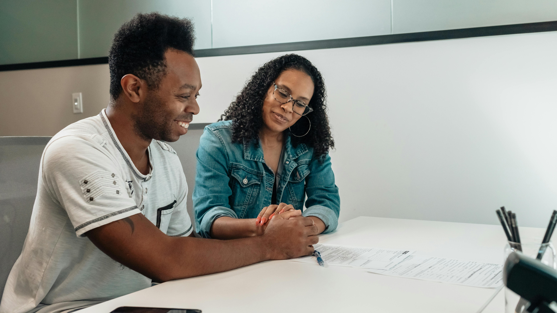 Couple happily reviewing mortgage loan documents together at a table