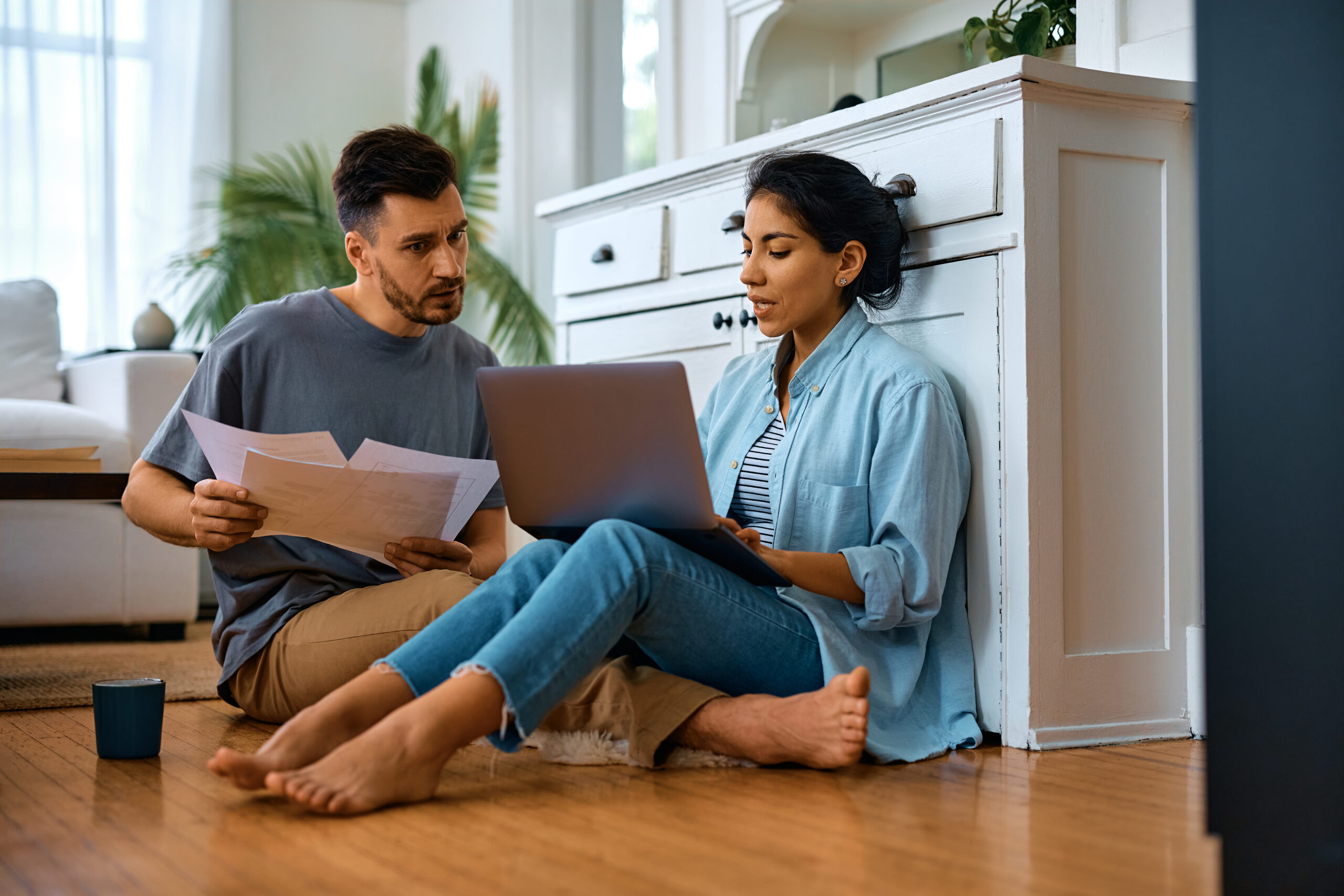 Couple reviewing mortgage paperwork and FHA refinance numbers together at home