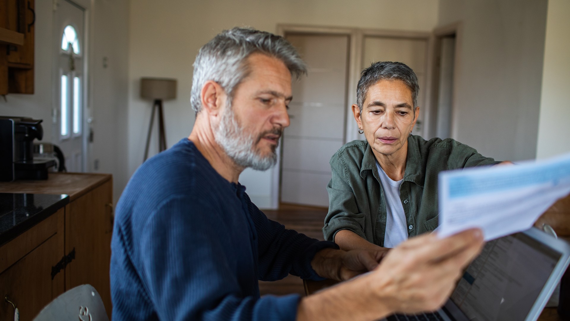 Couple at a kitchen table reviewing mortgage rate sheets and a calendar ahead of the June 17 Federal Reserve meeting.